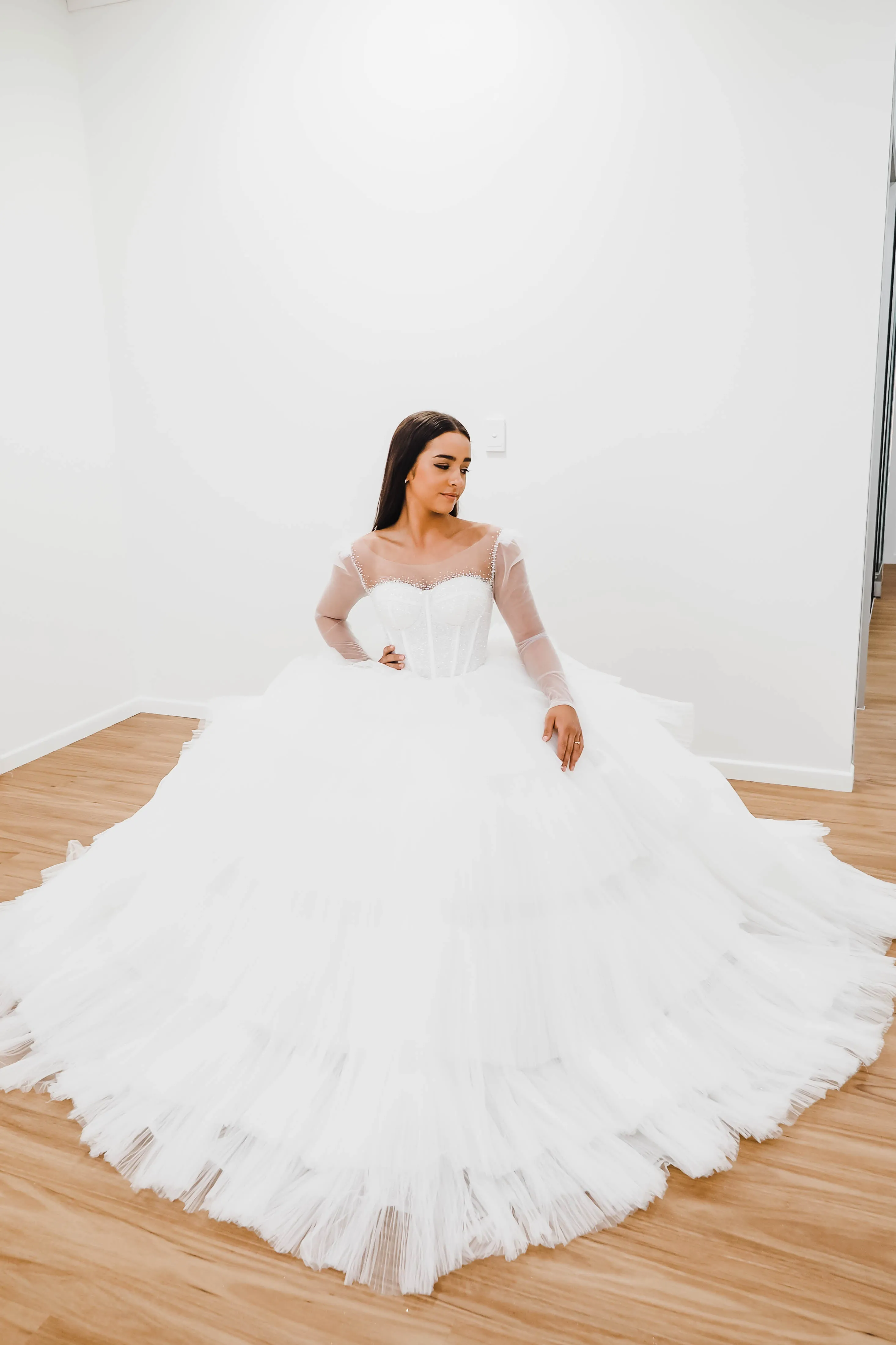 White wedding dress with a bushier top and a bushier puffy layered skirt.